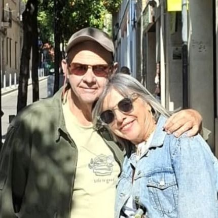 María Emilia Méndez y Pedro Solana, abrazados y sonriendo en una calle de Barcelona con naranjos